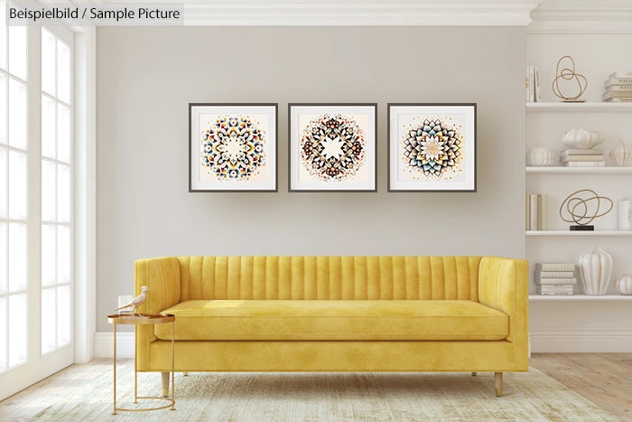 Modern living room with yellow couch and three abstract artworks on beige wall.