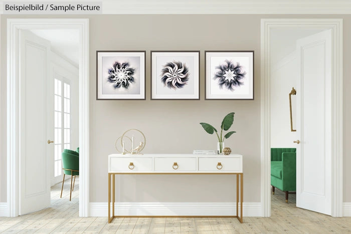 Modern hallway with three abstract framed artworks above a white console table and decorative plants.