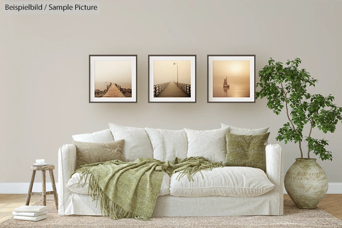 Stylish living room with white sofa, green cushions, and framed sepia photos on wall.