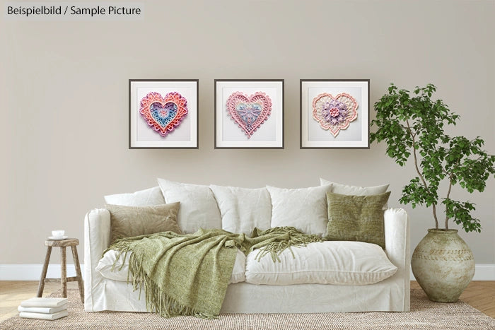 Living room with white sofa, green cushions, three framed heart artworks on wall, and a potted plant.