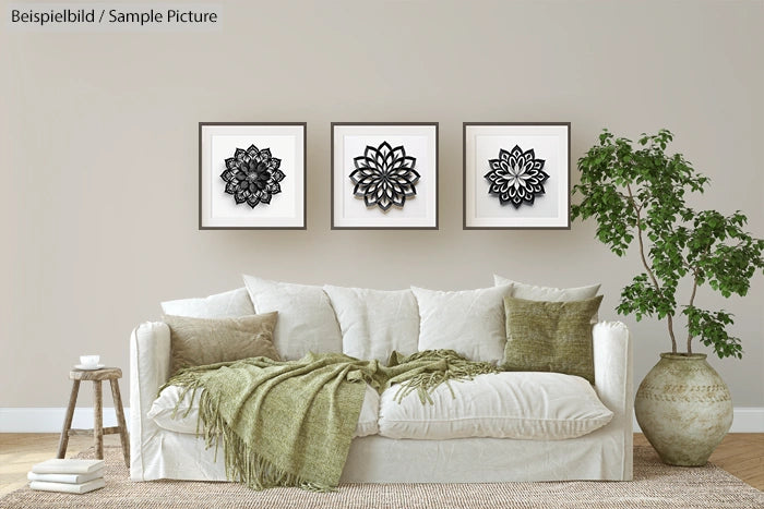 Living room with white sofa, green pillows, three framed mandala art pieces, and a potted plant on the side.