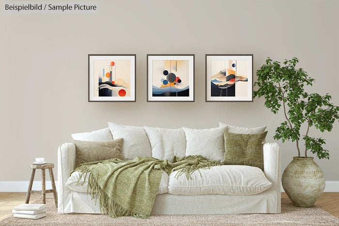 Modern living room with white sofa, green throw pillows and three abstract paintings on a beige wall.