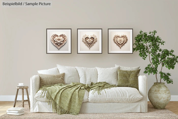 Elegant living room with a white sofa, green cushions, a throw blanket, and three framed heart artworks on the wall.