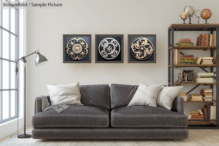 Modern living room with gray sofa, decorative circular wall art, and a bookshelf filled with books and globes.