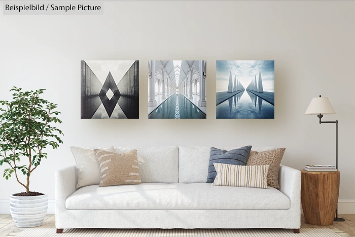 Modern living room with a white sofa, throw pillows, a potted plant, and three abstract art pieces on the wall.