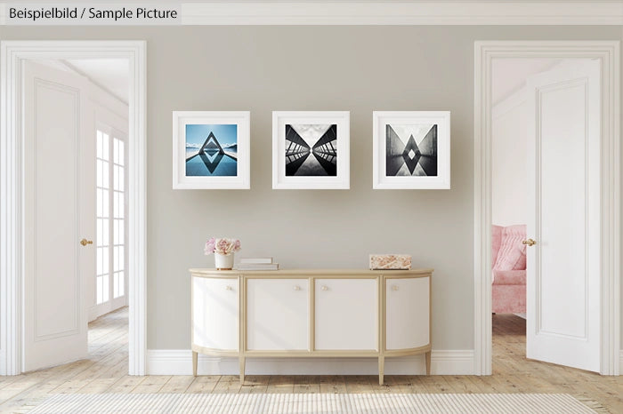 Modern living room with three framed abstract artworks above a sleek console table, flanked by two open doorways.