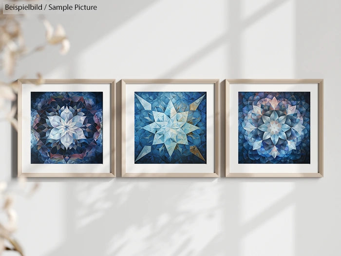 Three framed abstract geometric artworks with blue and white patterns displayed on a wall.