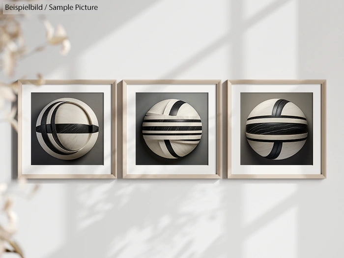 Three framed artworks with black and white abstract circular designs displayed on a wall.