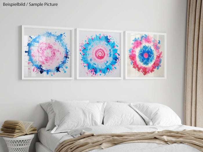 Bedroom with white bedding and three abstract art pieces in blue and pink above the bed.