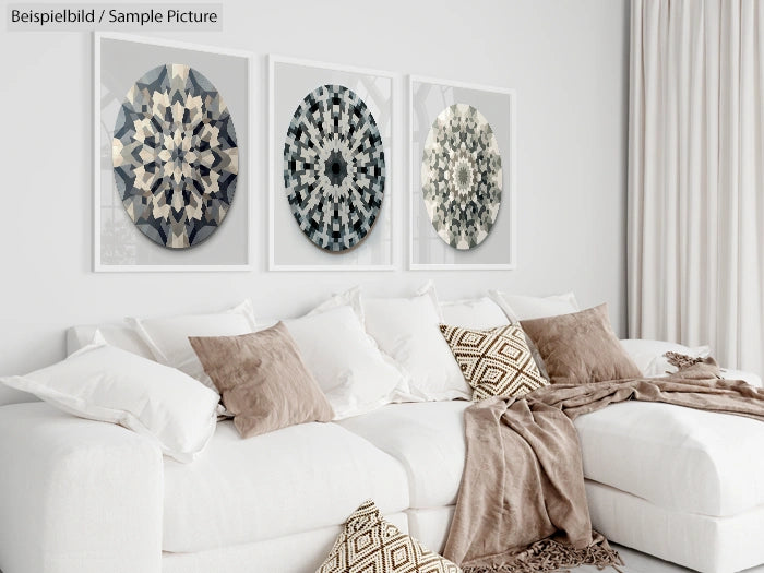 Modern living room with white sofa, brown pillows, and three abstract geometric prints on the wall.