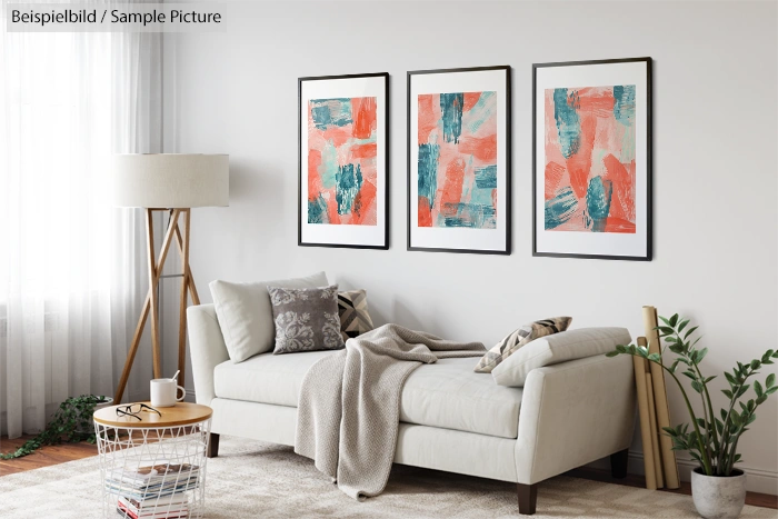 Modern living room with white sofa, abstract art, floor lamp, cushions, beige blanket, and green plant in a pot.