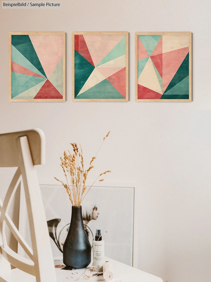 Minimalist room with geometric art on wall and vase on table.