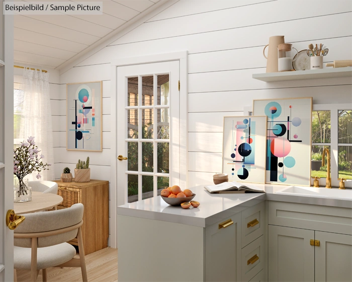 Bright kitchen with abstract art, wooden table, and fruit bowl on counter. Sunlight from glass door and window.