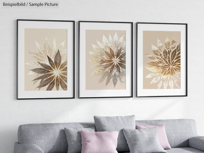 Three framed geometric leaf art prints above a gray sofa with a pink cushion.