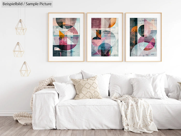 Modern living room with white sofa, abstract art prints on wall, and geometric pendant lights.