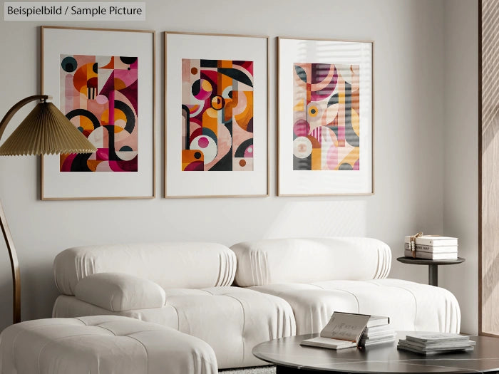 Modern living room with three abstract art pieces, white sofas, a stylish lamp, and a coffee table with books.