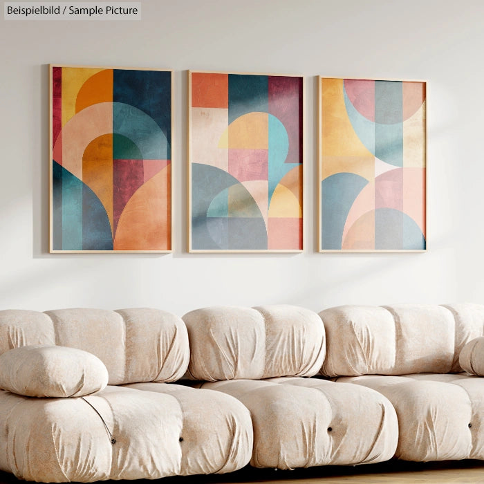 Modern living room with abstract geometric art triptych above a beige tufted sofa.