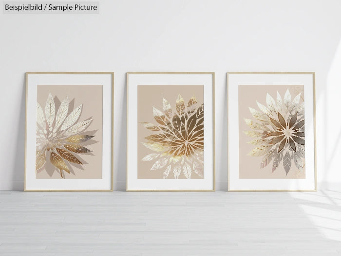 Three framed gold and beige floral artworks on a white wall in a minimalist room with wooden flooring.