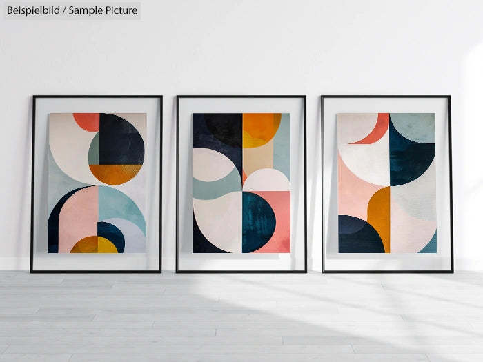 Three framed abstract paintings with geometric shapes and varied colors against a white wall.