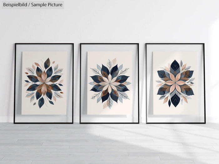 Three framed botanical art prints with symmetrical leaf patterns in blue and beige, displayed on a light gray wall.