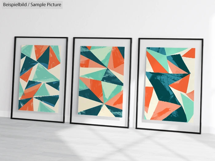 Three framed abstract geometric artworks with teal, orange, and beige triangles on a white wall.