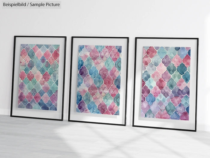 Three framed watercolor prints with geometric patterns in pastel colors on a light wall.