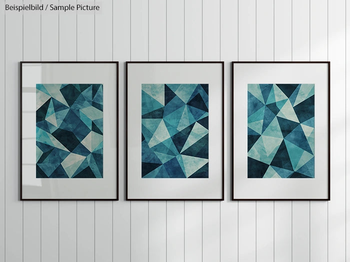 Three framed abstract teal and blue geometric prints on a white striped wall.