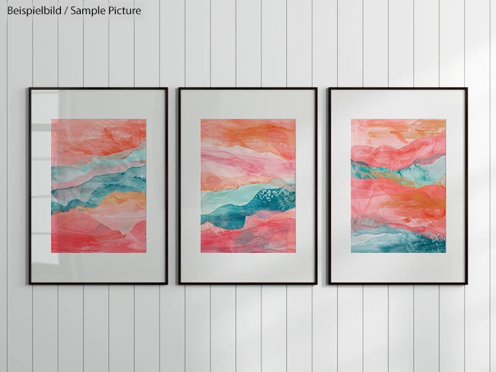 Three framed abstract paintings with pink, blue, and orange swirls on a white wall.