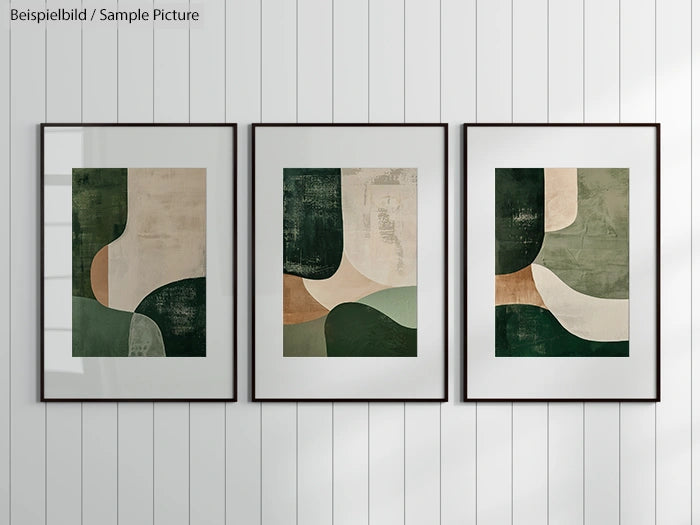 Three framed abstract paintings with green and beige geometric shapes on a white paneled wall.