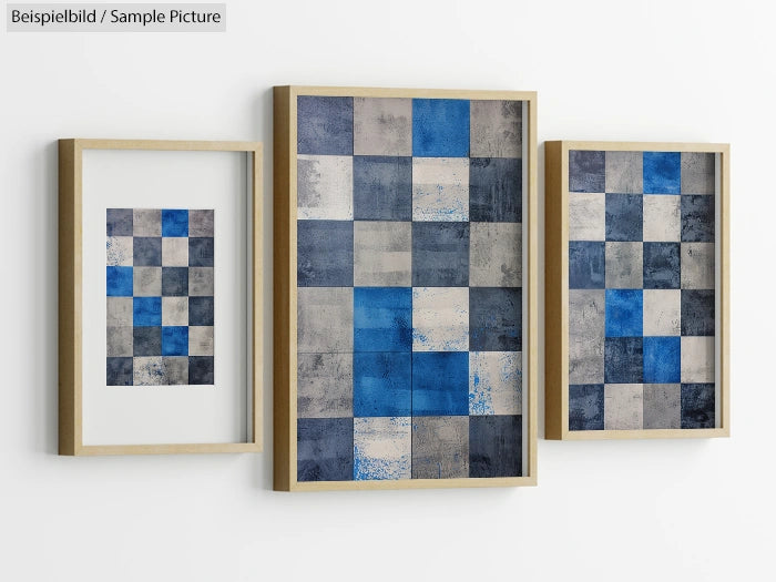 Three framed abstract paintings with blue, gray, and beige geometric patterns on a white wall.