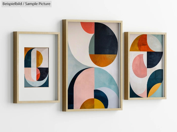 Three framed abstract geometric artworks with colorful shapes in circles and arches on a white wall.