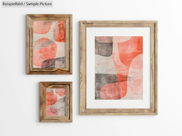 Gallery wall with three framed abstract paintings featuring red, orange, and gray shapes on a white background.