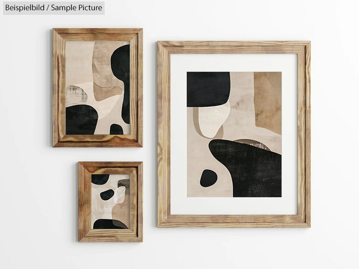 Three framed abstract paintings with beige, black, and brown organic shapes on a white wall.