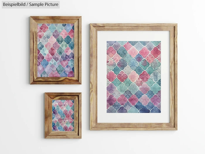 Three framed watercolor paintings with geometric patterns in shades of blue, pink, and purple on a white wall.