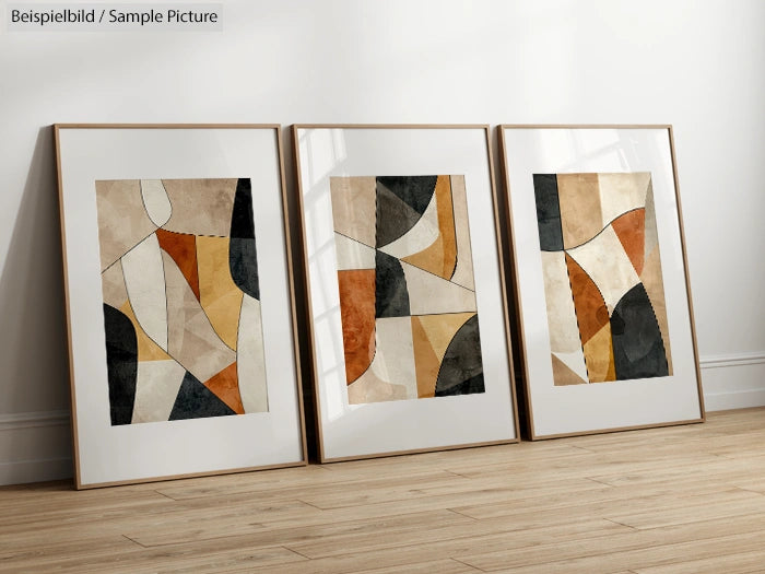 Three framed abstract paintings with geometric shapes in warm earth tones, leaning against a white wall on a wooden floor.