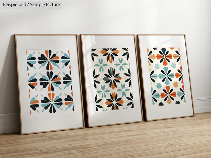 Three framed abstract floral artworks with geometric patterns, displayed on a wooden floor.