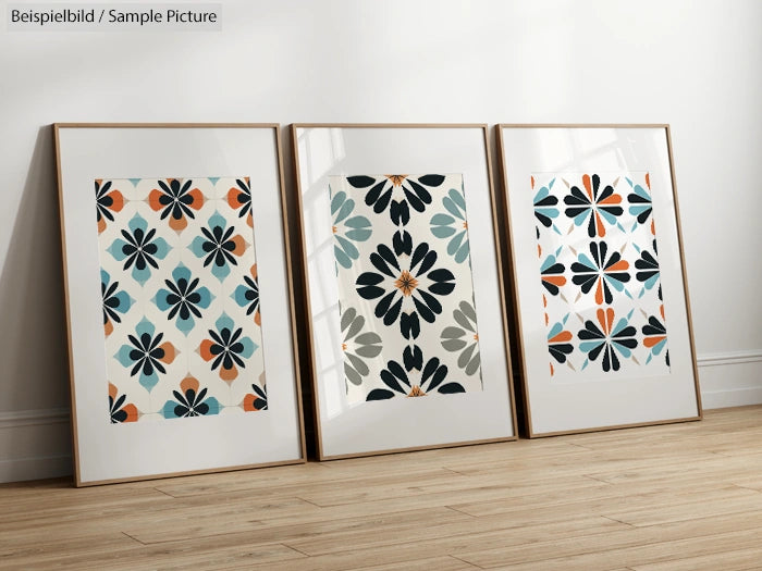 Three framed abstract prints with floral patterns in a room with wooden floor.